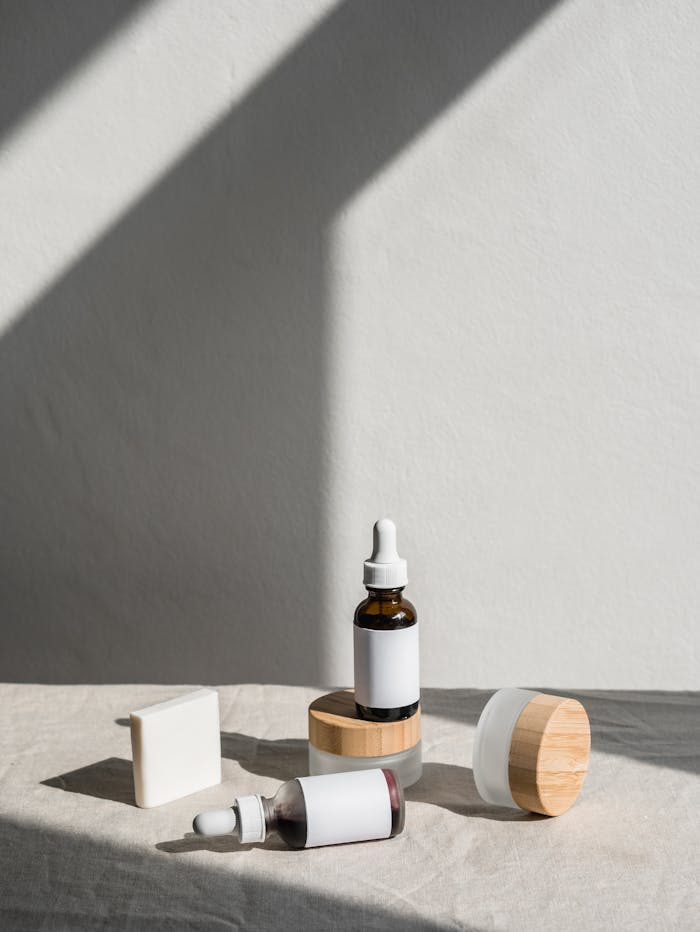 Stylish layout of skincare products with dropper bottles and jars against a soft backdrop.